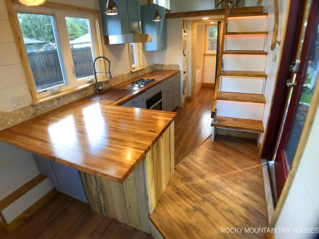 The Bradford 26' Tiny House's kitchen is spacious and includes a breakfast bar for two